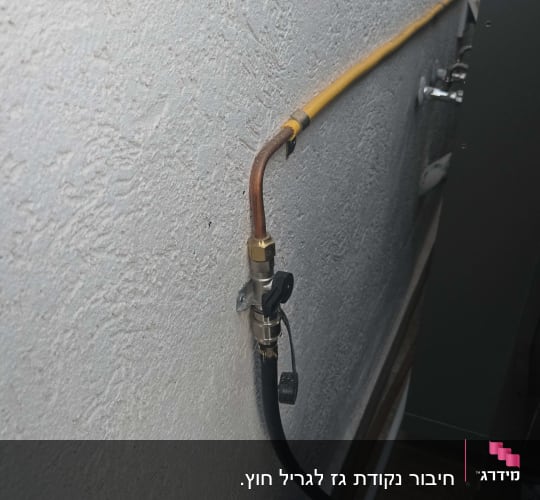 צינור גז צהוב מחובר לשסתום על קיר